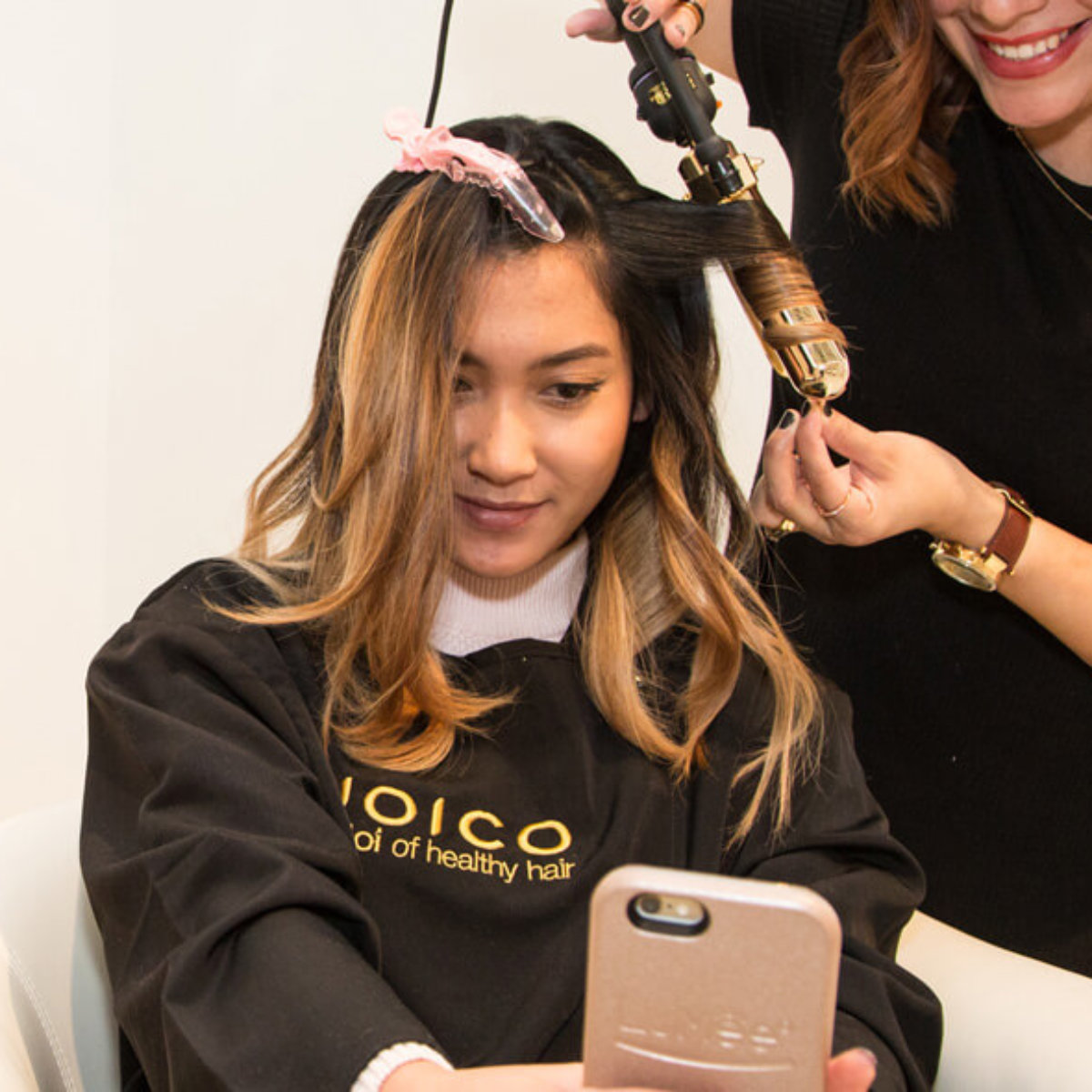 Womens hair being curled by a hairstylist