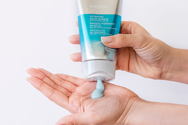HydraSplash-masque-in-hand Hair styling product being coming out of bottle into hand