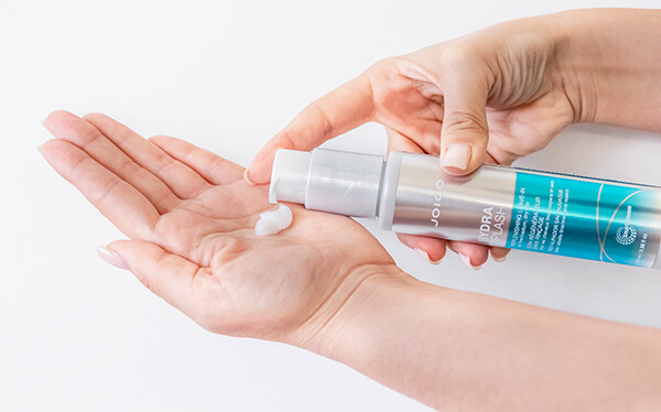 HydraSplash-styler-in-hand Hair styling product being coming out of bottle into hand