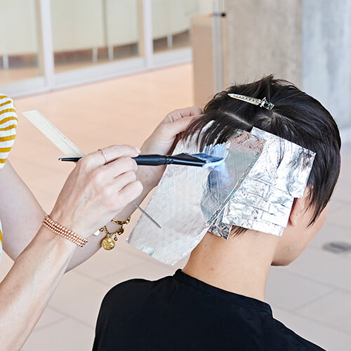 Hairstylist Jill Buck coloring clients hair