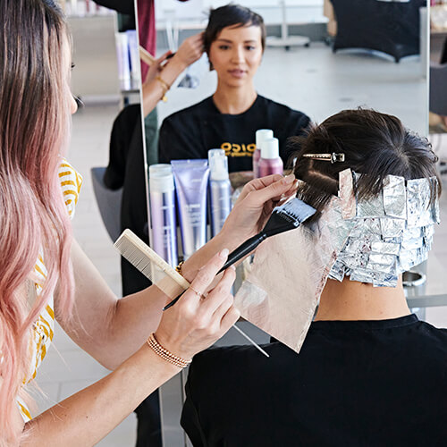 Hairstylist Jill Buck coloring clients hair