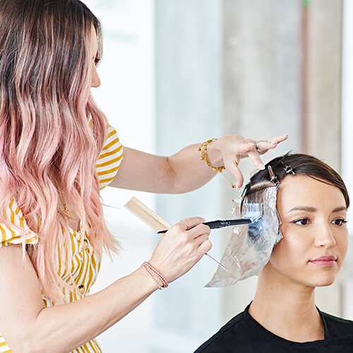 Hairstylist Jill Buck coloring clients hair