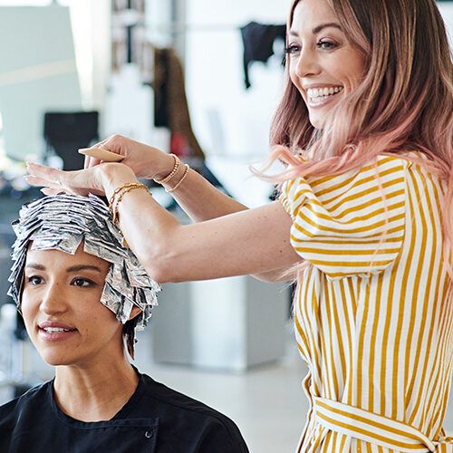 Hairstylist Jill Buck coloring clients hair